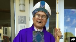 FILE - Archbishop Anthony Apuron stands in front of the Dulce Nombre de Maria Cathedral Basilica in Hagatna, Guam, in November 2014.