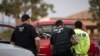 FILE - U.S. Immigration and Customs Enforcement agents surround and detain a person during a raid.