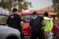 FILE - U.S. Immigration and Customs Enforcement (ICE) officers detain a man during an operation in Escondido, California, July 8, 2019.