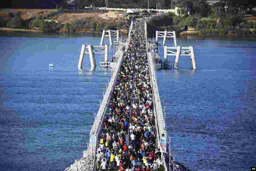 Hundreds of Mombasa residents cross the recently built floating foot bridge from Mombasa&#39;s Likoni mainland to the Mombasa Island, Kenya.