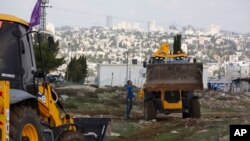 Para pekerja beristirahat sebelum pejabat Uni Eropa mengunjungi lokasi konstruksi untuk pemukiman Givat Hamatos di Yerusalem. (Foto: dok). Israel, Senin, 12 Januari 2021, memajukan rencana untuk membangun 800 rumah pemukim baru di Tepi Barat. (AP Photo/Maya Alleruzzo).