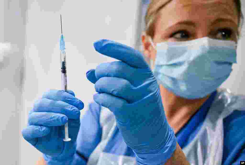 Paula McMahon prepares a shot of the Pfizer-BioNTech COVID-19 vaccine, as the mass public vaccination program gets underway, at the NHS Louisa Jordan Hospital in Glasgow, Scotland, Dec. 8, 2020.