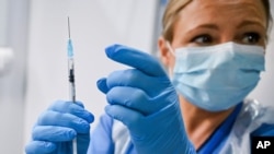 Paula McMahon prepares a shot of the Pfizer-BioNTech COVID-19 vaccine, as the mass public vaccination program gets underway, at the NHS Louisa Jordan Hospital in Glasgow, Scotland, Dec. 8, 2020.