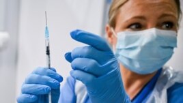 Paula McMahon prepares a shot of the Pfizer-BioNTech COVID-19 vaccine, as the mass public vaccination program gets underway, at the NHS Louisa Jordan Hospital in Glasgow, Scotland, Dec. 8, 2020.