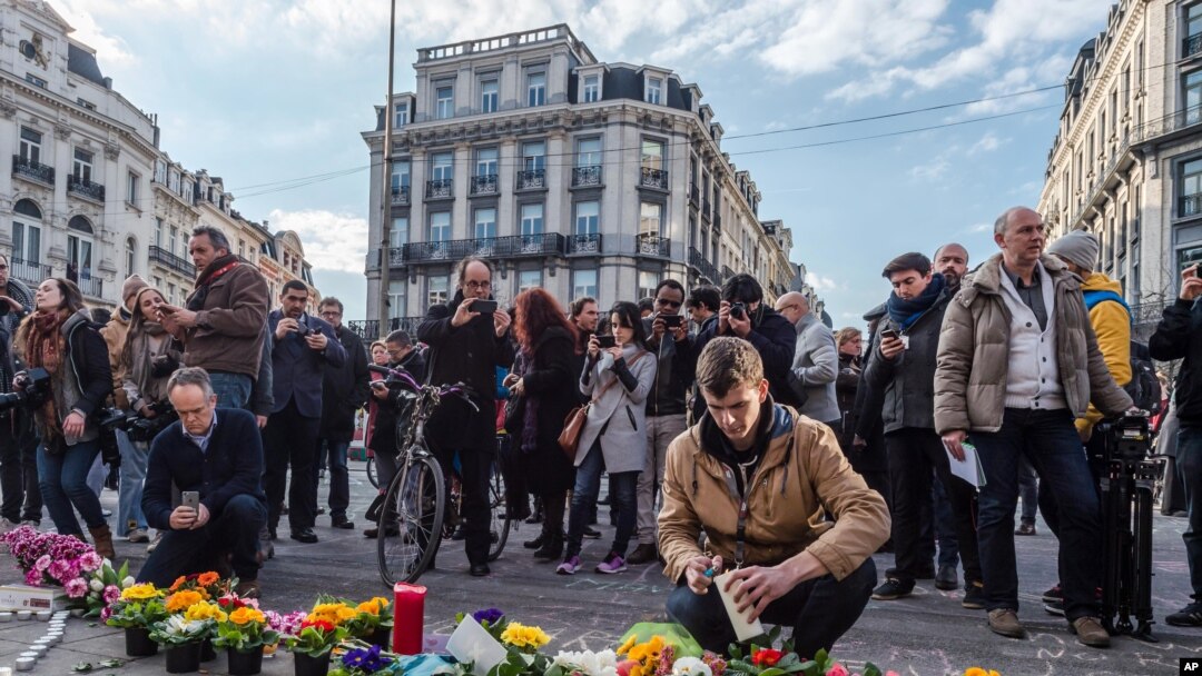 People light candles at a memorial set up outside the stock exchange in Brussels on March 22, 2016. 