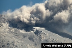 Gunung Lewotobi memuntahkan abu vulkanik dari kawahnya saat terjadi letusan seperti terlihat dari Desa Duripali di Flores Timur, Nusa Tenggara Timur, 12 Oktober 2024. (Foto: Arnold Welianto/AFP)