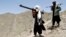 FILE - Afghan Taliban fighters are seen carrying weapons, May 27, 2016.