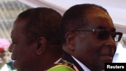 Zimbabwean President Robert Mugabe (R) and Prime Minister Morgan Tsvangirai arrive at a rally marking Zimbabwe's 31st independence anniversary celebrations in Harare, Zimbabwe, April 18, 2011. 