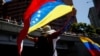 Un partidario de la oposición venezolana sostiene la bandera de Venezuela mientras se reúne con otros partidarios antes de la toma de posesión del presidente Nicolás Maduro para un tercer mandato, en Caracas, Venezuela, el 9 de enero de 2025. REUTERS/Leonardo Fernández Viloria.