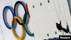 A construction worker prepares to pain a wall ahead of the 2014 Sochi Winter Olympic Games at the "Laura" cross-country and biathlon centre in Rosa Khutor, Feb. 5, 2014. 