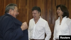 El presidente colombiano Juan Manuel Santos, centro, y su canciller María Angela Holguin, conversa con el presidente Raul Castro, en La Habana.