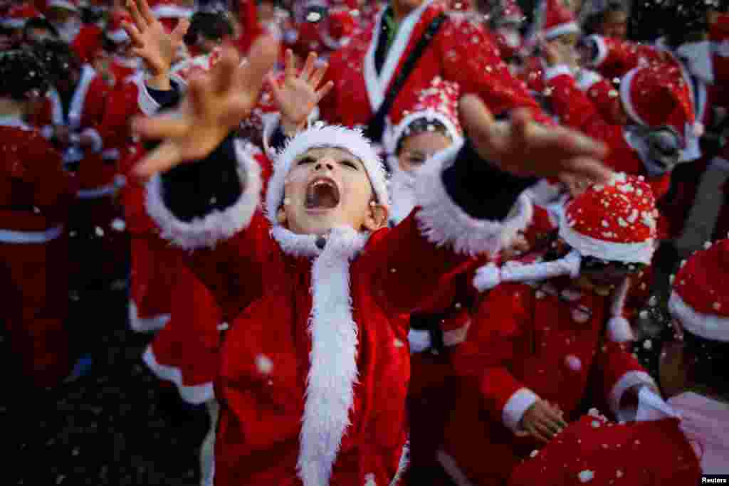 Santa Klaus kimi geyinmiş uşaqlar paradda ehtiyacı olanlar üçün ərzaq toplayır. Lissabon, Portuqaliya.