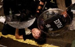 A demonstrator is detained by police officers during a protest in Hong Kong, Aug. 31, 2019.