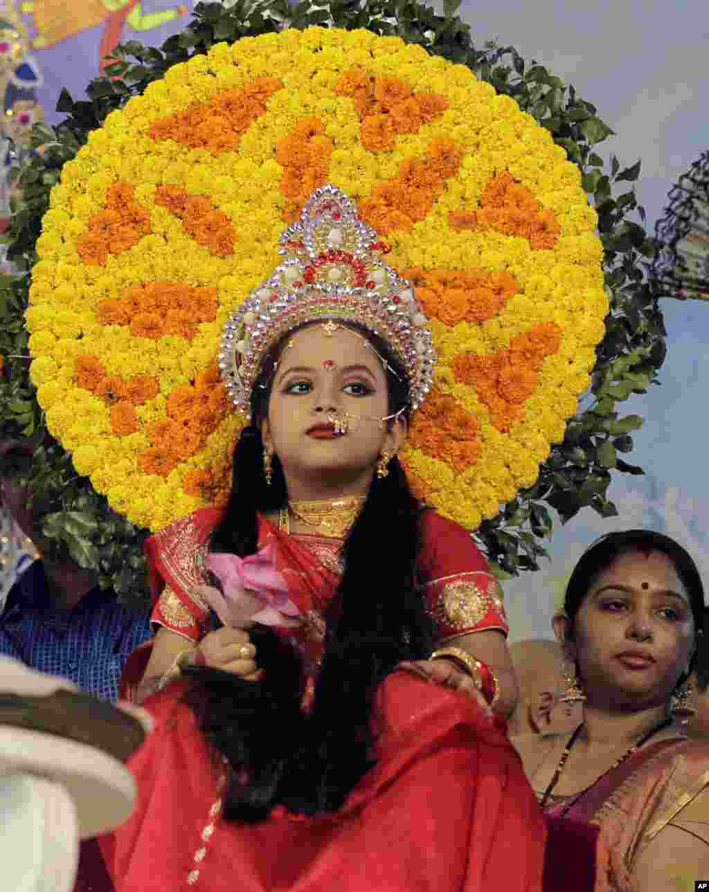 یک دختر جوان در معبدی در داکا، پایتخت بنگلادش، در حال انجام مراسم مذهبی است. او در نقش یک الهه در این مراسم ظاهر شده است. &nbsp;