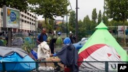 Migran duduk bersama di pemukiman migran darurat di kawasan La Chapelle di tepi utara kota Paris, Perancis, 17 Agustus 2017. (Foto: dok).