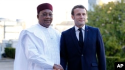 FILE - French President Emmanuel Macron, right, greets Niger President Mahamadou Issoufou prior to a meeting at the G5 Sahel summit in Pau, France, January13, 2020. On December 3, 2023, Niger and Burkina Faso announced they would withdraw from the group.