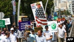 
Turkish supporters of Egypt's ousted president Mohamed Morsi hold portrait mocking General Abdel Fattah al-Sisi during demonstration condemning deadly crackdown in Cairo, outside Egyptian embassy, Ankara, August 14, 2013.