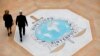 In this photo taken on Thursday, Nov.8, 2018 people walk on the Interpol logo at the international police agency headquarters in Lyon, central France.