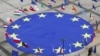 FILE - A large European Union flag lies at the center of Schuman Square outside European Commission headquarters in Brussels, Belgium, May 8, 2021. 