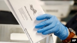 FILE - A worker processes mail-in ballots at the Bucks County Board of Elections office prior to a primary election, in Doylestown, Pennsylvania, May 27, 2020. Nevada has just adopted mail-in voting for the November general election.