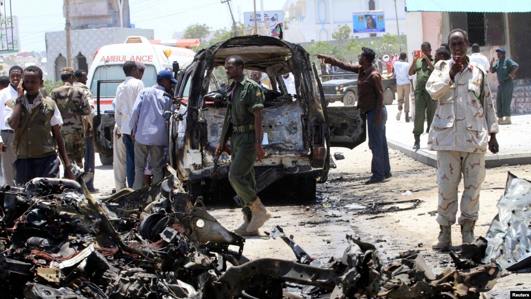 Seorang tentara menggunakan telepon genggamnya untuk memotret mobil yang hancur di lokasi ledakan dekat istana presiden di Mogadishu, Somalia (18/3).