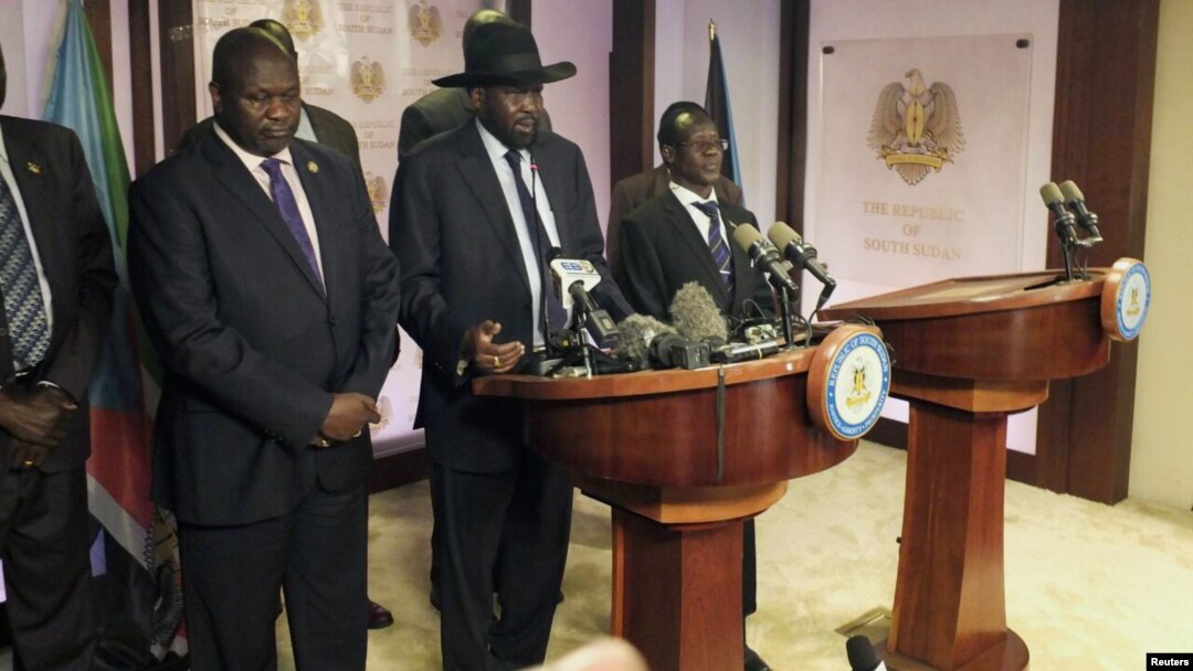 South Sudan President Salva Kiir, center, flanked by former rebel leader Riek Machar, left, and other government officials, addresses a news conference at the Presidential State House in Juba, South Sudan, July 8, 2016. 