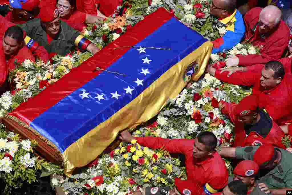 Peti berbalut bendera berisi jenazah Presiden Venezuela Hugo Chavez dibawa dari rumah sakit tempat ia meninggal menuju akademi militer di Caracas (6/3). (AP/Ricardo Mazalan)