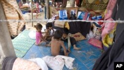 Cambodian refugee children play under a tent at a refugee camp of Ta Keung village, about 70 kilometers (43 miles) south of Cambodia's 11th century Hindu Preah Vihear temple near the deputed border between Cambodia and Thailand, in Preah Vihear province, 