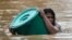 A resident uses a plastic container as a floater while negotiating rising floodwaters in Marikina, Philippines due to Typhoon Vamco on Thursday, Nov. 12, 2020. A typhoon swelled rivers and flooded low-lying areas as it passed over the storm-battered…