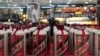 FILE - A customer walks past a glass case displaying Maotai liquors at a supermarket in Shenyang, Liaoning province, Aug. 8, 2012.