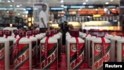 FILE - A customer walks past a glass case displaying Maotai liquors at a supermarket in Shenyang, Liaoning province, Aug. 8, 2012.