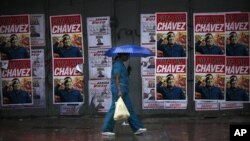 Seorang wanita berjalan melewati sebuah tembok yang tertutup poster kampanye Presiden Hugo Chavez sebagai calon Presiden, dalam Pemilihan Presiden Venezuela di Caracas (Foto: dok). Venezuela akan menggelar Pemilihan Presiden, Minggu ini (7/10). 