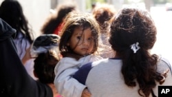 FILE - Immigrant families walk to a respite center after they were processed and released by U.S. Customs and Border Protection, June 27, 2018, in McAllen, Texas.