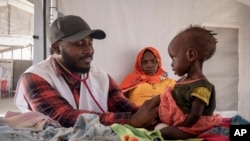 FILE - A doctor treats a Sudanese child suffering from malnutrition are treated at an MSF clinic in Metche Camp, Chad, near the Sudanese border, on April 6, 2024. 