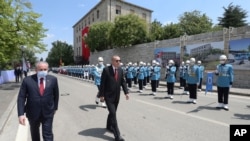 Turkey's President Recep Tayyip Erdogan, center, inspects a military honor guard as he arrives at the parliament for a ceremony, in Ankara, Turkey, July 15, 2020. 
