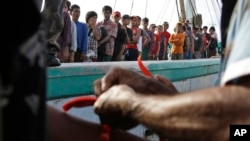 Pejabat pemerintah memberi gelang pada nelayan-nelayan Myanmar sebagai alat identifikasi saat tiba di Tual, 4 April 2015.