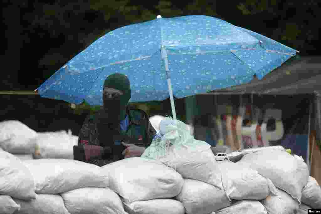 A pro-Russian fighter mans a checkpoint in the eastern Ukrainian city of Donetsk, July 7, 2014. 