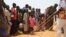 Children queue for food distributed by an NGO in the makeshift camp of Saguia near the capital Niamey, on Sept. 11, 2019, after the Niger river floods forced residents from the area.