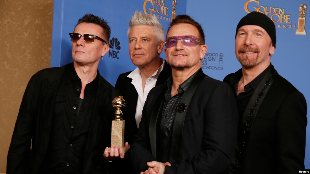 Para personil U2, Adam Clayton (kiri), Bono (kedua dari kanan), Larry Mullen, Jr. dan The Edge (kanan), berfoto setelah menerima penghargaan Best Original Song, 12 Januari 2014.
