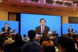 National People's Congress spokesman Zhang Yesui is seen on screens during a news conference held via video link ahead of the annual parliament meeting in Beijing, China, March 4, 2021.