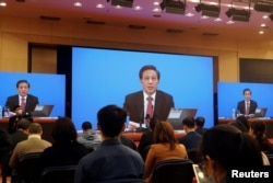 National People's Congress spokesman Zhang Yesui is seen on screens during a news conference held via video link ahead of the annual parliament meeting in Beijing, China, March 4, 2021.