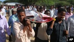 FILE - Somalis and local journalists carry the body of Moqtar Mohamed Hirab for burial in Mogadishu, Somalia.