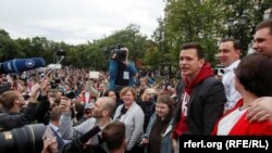 Tokoh oposisi Rusia, Ilya Yashin (ketiga dari kanan/baju merah) berbicara di depan pendukungnya pada aksi protes di Moskow, Minggu (14/7). 