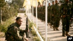 U.S.-backed Syrian Democratic Forces (SDF) stand in formation at a ceremony to mark their defeat of Islamic State militants in Baghuz, at al-Omar Oil Field base, Syria, March 23, 2019. 