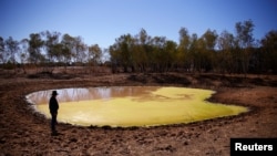 Farmer Tony Jackson inspects a dam containing stagnant water on his property located near Deadman's Creek on the outskirts of the outback town of Stonehenge, in Queensland, Australia, Aug. 13, 2017.