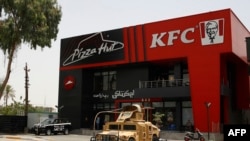 Vozila iračkih snaga sigurnosti stacionirana su ispred restorana brze hrane Kentucky Fried Chicken (KFC) i Pizza Hut u četvrti Al-Jadriya u Bagdadu 30. maja 2024.