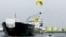 A member of Greenpeace in a hang-glider, carrying a banner saying "No Arctic Oil", flies over the Russian oil tanker Mikhail Ulyanov in the harbour of Rotterdam May 1, 2014.