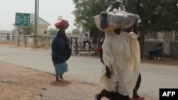 FILE —Women walk by the closed Niger-Nigeria border in Jibia on February 17, 2024. Nigeria, which shares 1,600 km of border with its neighbor, was one of Niger's main trading partners with $193 million in exports in 2022 according to the United Nations (electricity, tobacco,etc).