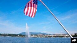 FILE - The United States flag waves on a bridge near the fountain Jet d'eau in the Lake Geneva in Geneva, Switzerland, Tuesday, June 15, 2021. 