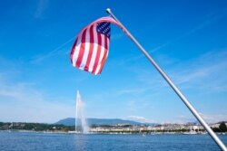 The United States flag waves on a bridge near the fountain Jet d'eau in the Lake Geneva in Geneva, Switzerland, June 15, 2021.